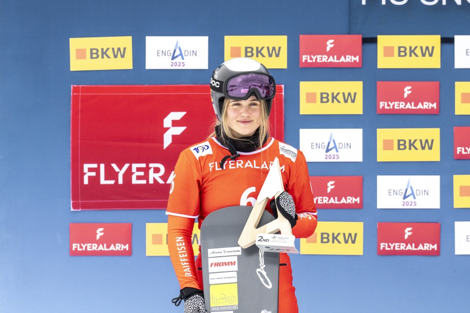 Snowboarder Sophie Hediger holding second-place trophy.