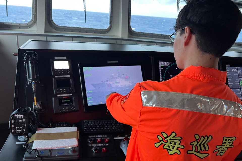 Taiwan Coast Guard crewmember monitoring a Chinese coast guard vessel on a ship's screen.