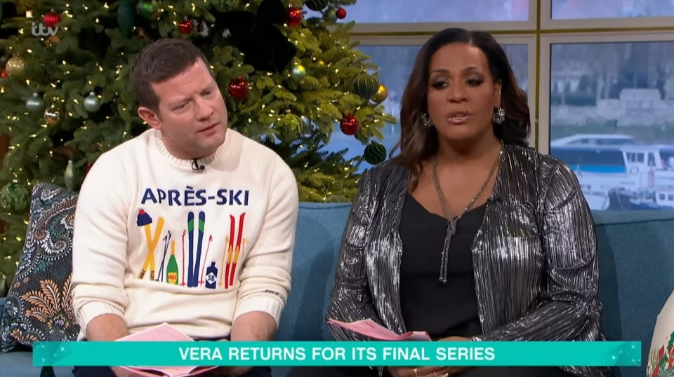 Two presenters sit on a sofa in front of a Christmas tree, discussing the final series of Vera.