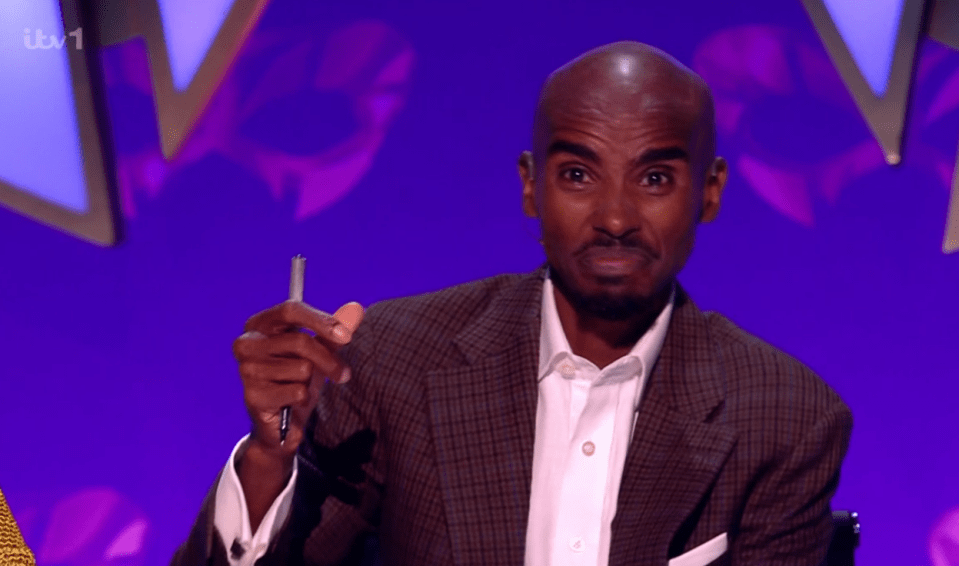 Mo Farah holding a pen.