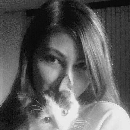 Black and white photo of a woman holding a kitten.