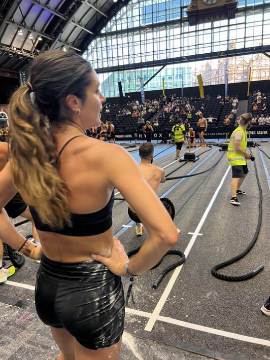 Woman watching Hyrox competition.