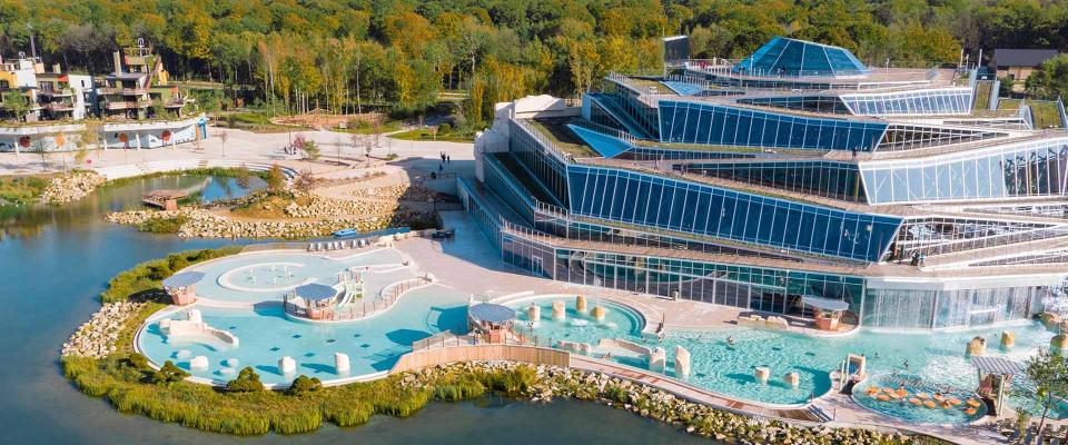 Aerial view of Villages Nature Paris, featuring a large aquatic center and surrounding buildings.