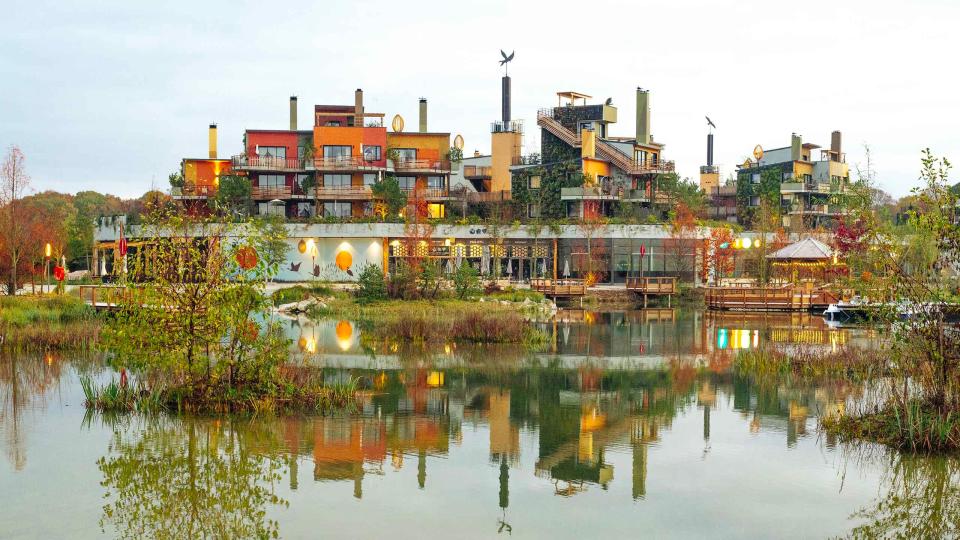 Reflective pond in front of Villages Nature Paris buildings.