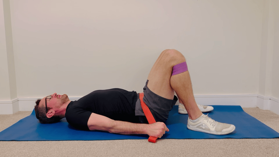 Man using resistance bands for glute bridge exercise.