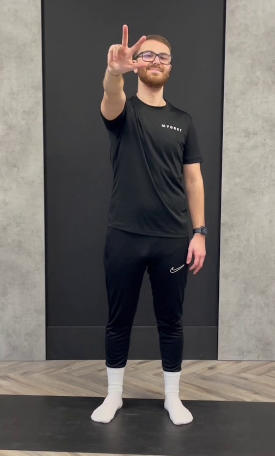 Man demonstrating a stretch on a yoga mat.