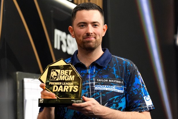 Luke Humphries holding a Premier League Darts trophy.