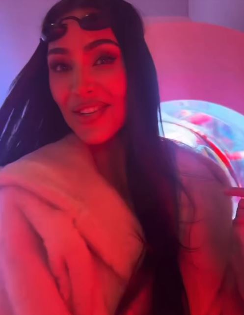 Kim Kardashian using a red light therapy mask.