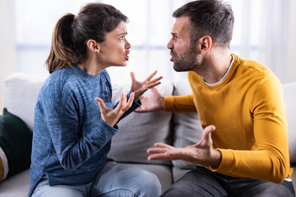 A couple arguing on a couch.