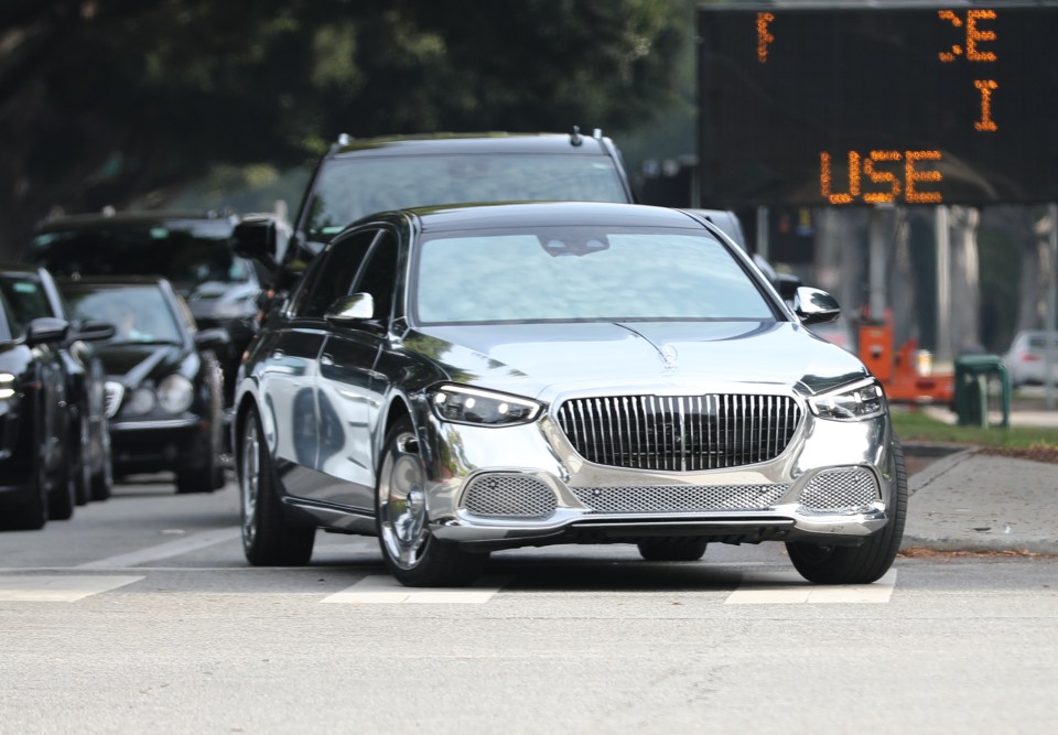 Chrome Mercedes driving through traffic.