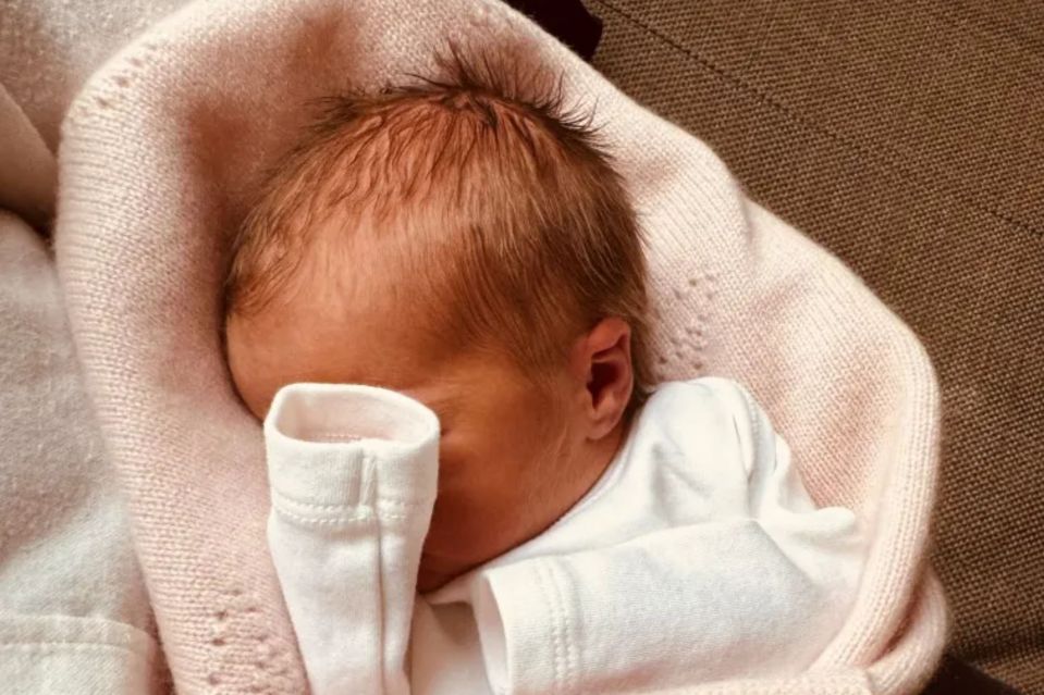 Newborn baby girl Athena in a pink blanket.