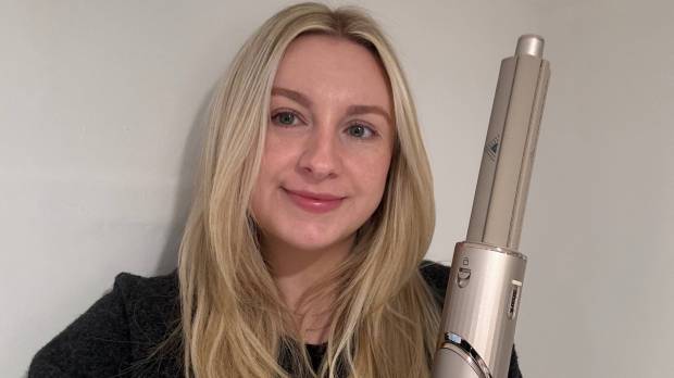 Woman holding a Shark Flexstyle hair tool.