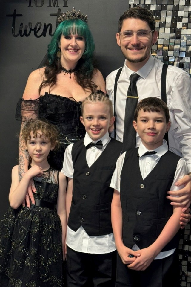 Family portrait of a woman in a black dress, a man in a white shirt and black suspenders, and three children in black vests.