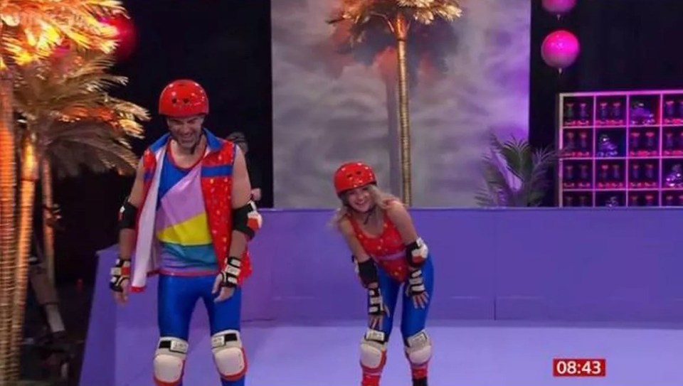 Gethin Jones and Helen Skelton roller-skating on a TV show.