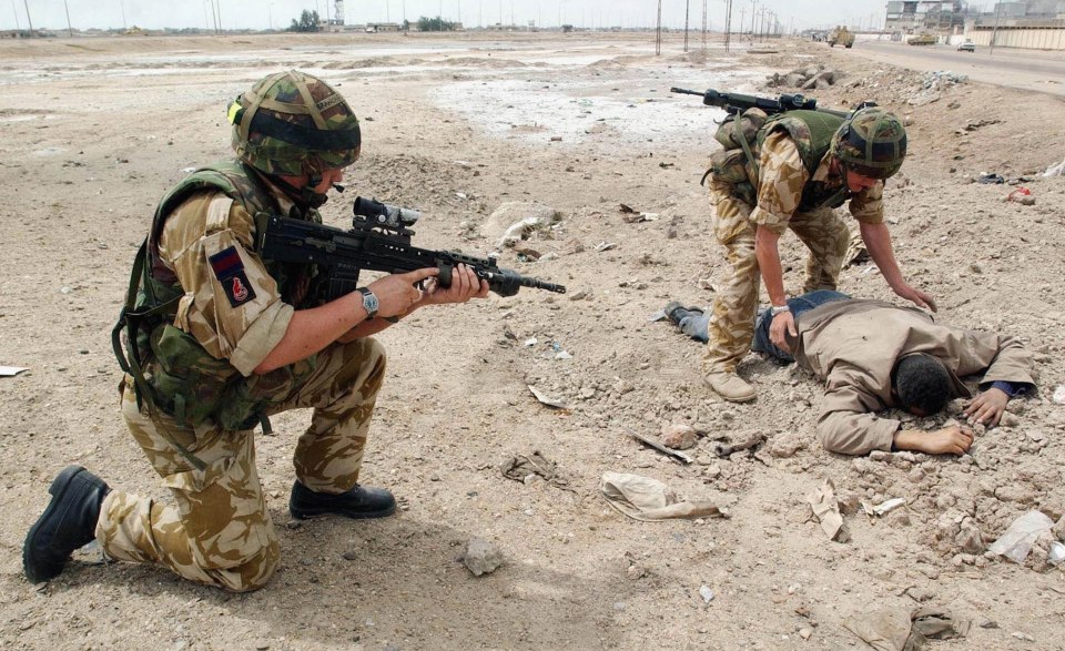 British soldiers searching a civilian in Basra, Iraq.