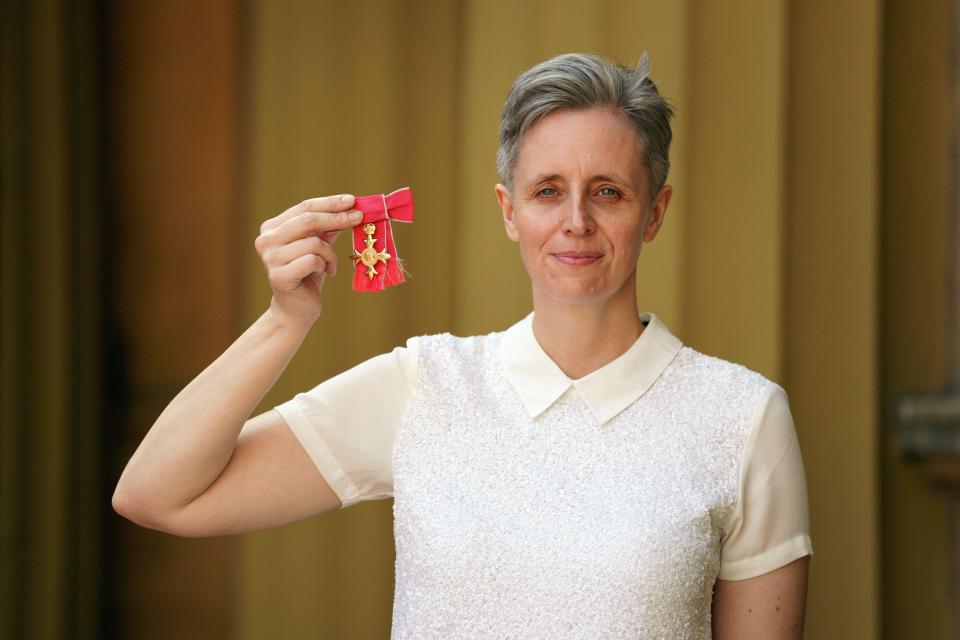 Professor Kathleen Stock holding her OBE medal after an investiture ceremony at Buckingham Palace.