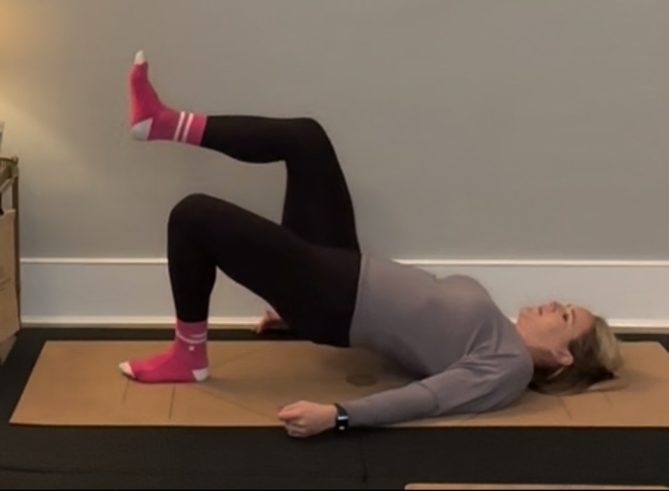 Woman performing a glute bridge exercise.