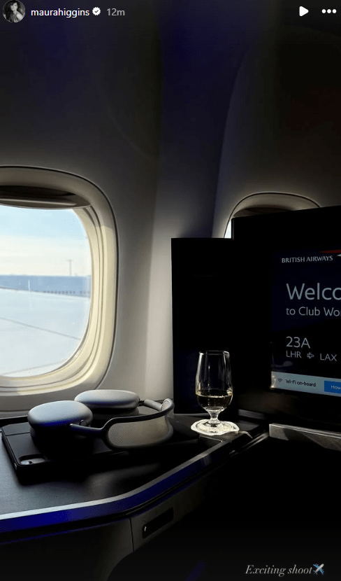 British Airways Club World seat with noise-canceling headphones, a glass of wine, and an in-flight entertainment screen.