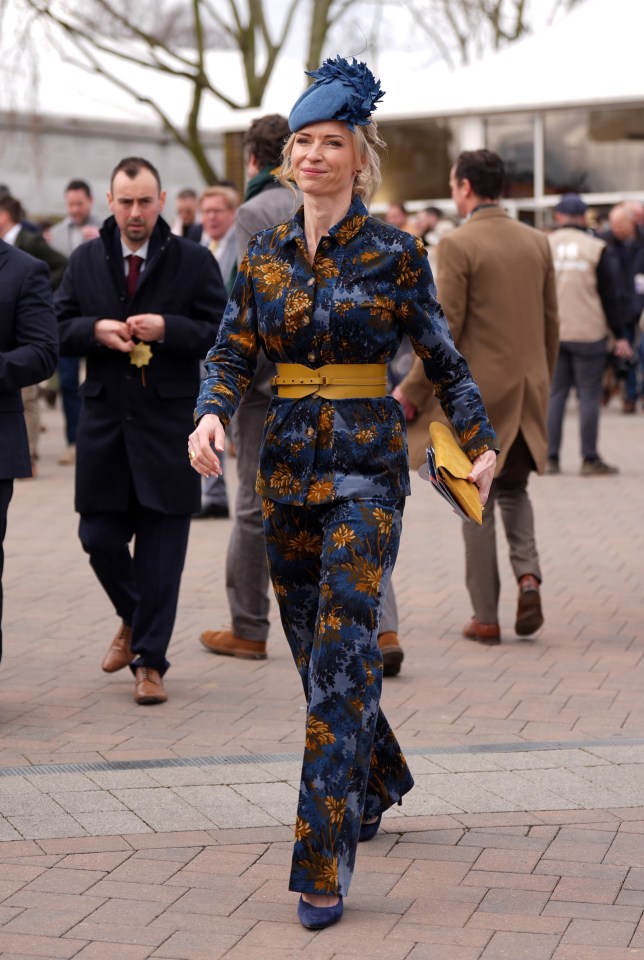 Woman in floral pantsuit at a horse race.