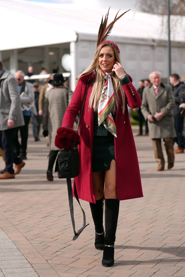 Woman in red coat and hat at a horse race.