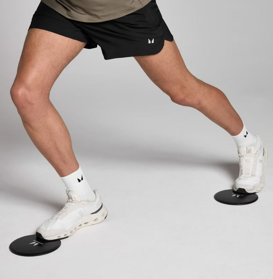 Person performing a leg exercise using sliding discs.