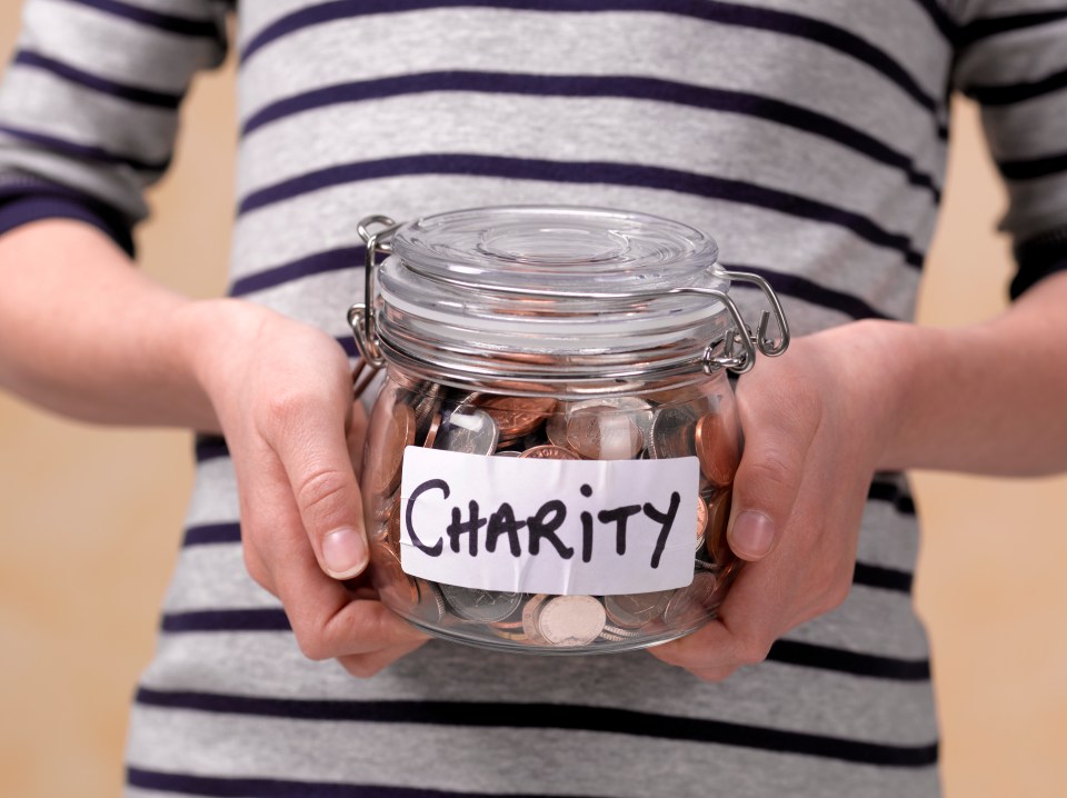 Child holding a jar of coins labeled "Charity."