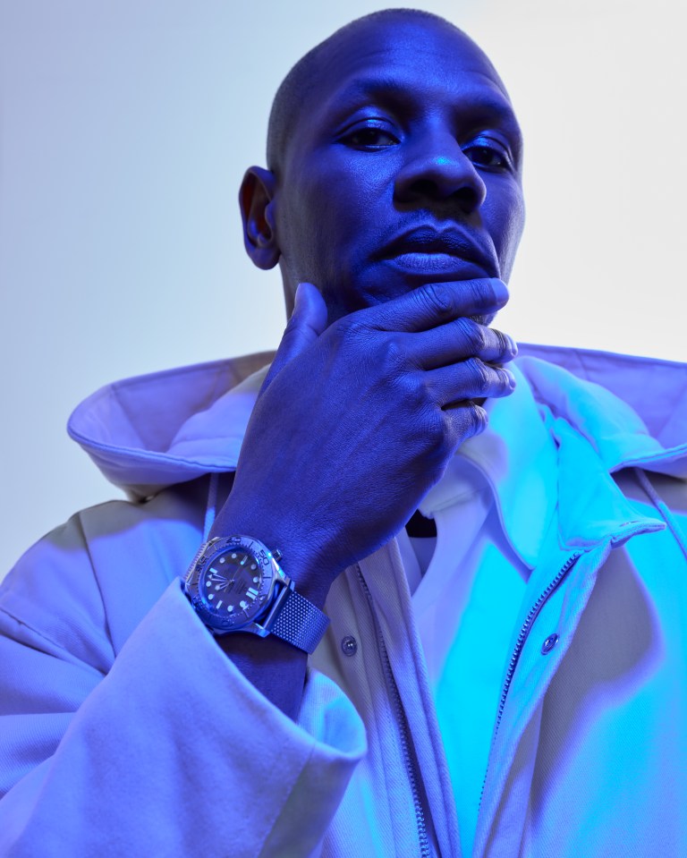 Portrait of a man wearing a white jacket and wristwatch.