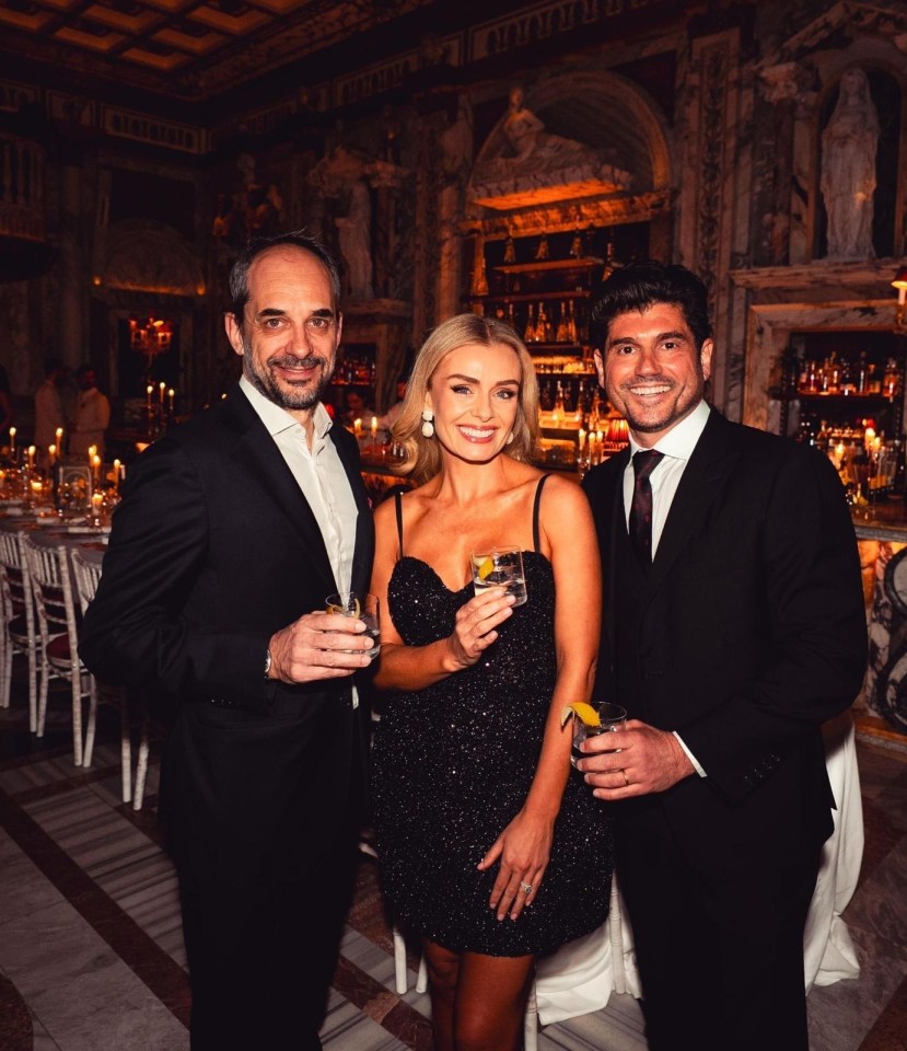 Three people holding drinks at a formal event.