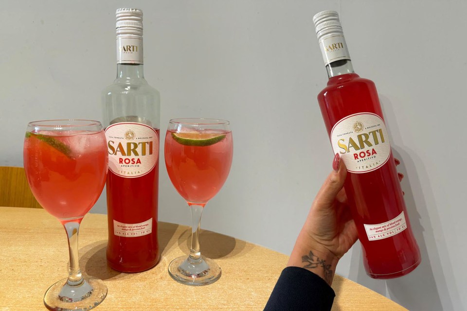 Two glasses of Sarti Rosa aperitivo with a bottle of the drink.
