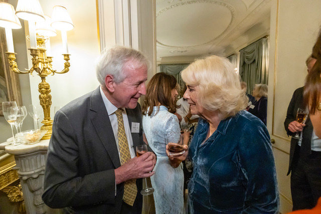 A man and Queen Camilla talking at an event.