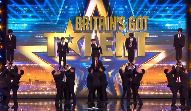 Britain's Got Talent performers in suits forming human pyramids.