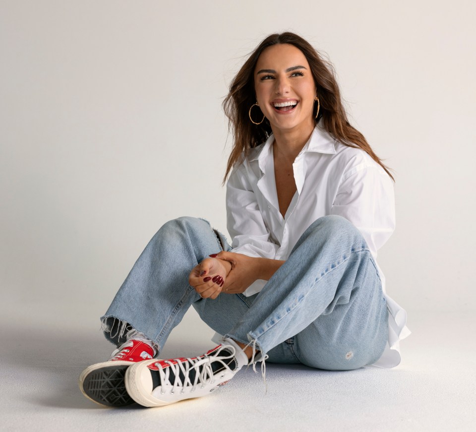 Woman sitting on the floor smiling.