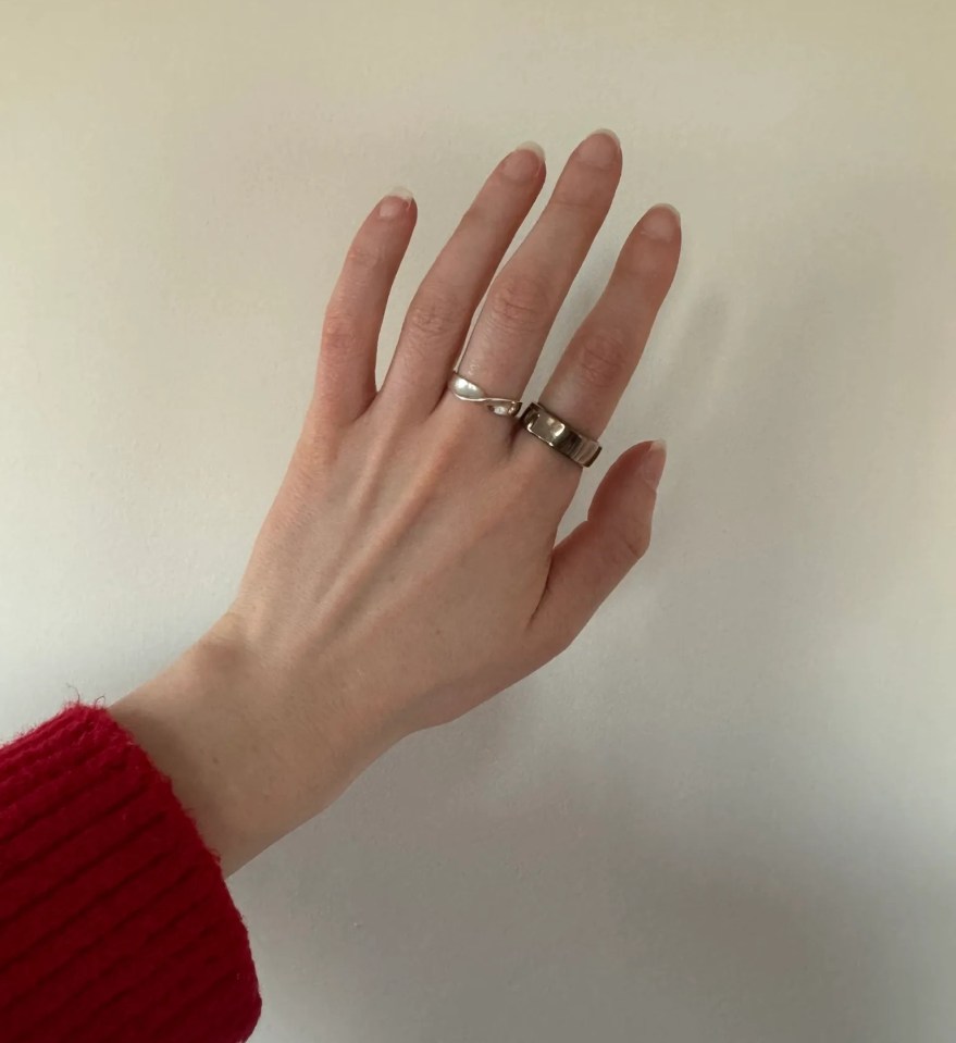 Hand wearing two rings.