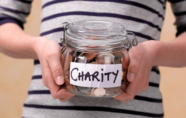 Child holding a jar of coins labeled "Charity."