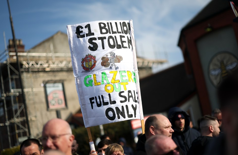 Protest sign reading "£1 billion stolen, Glazers out, full sale only".