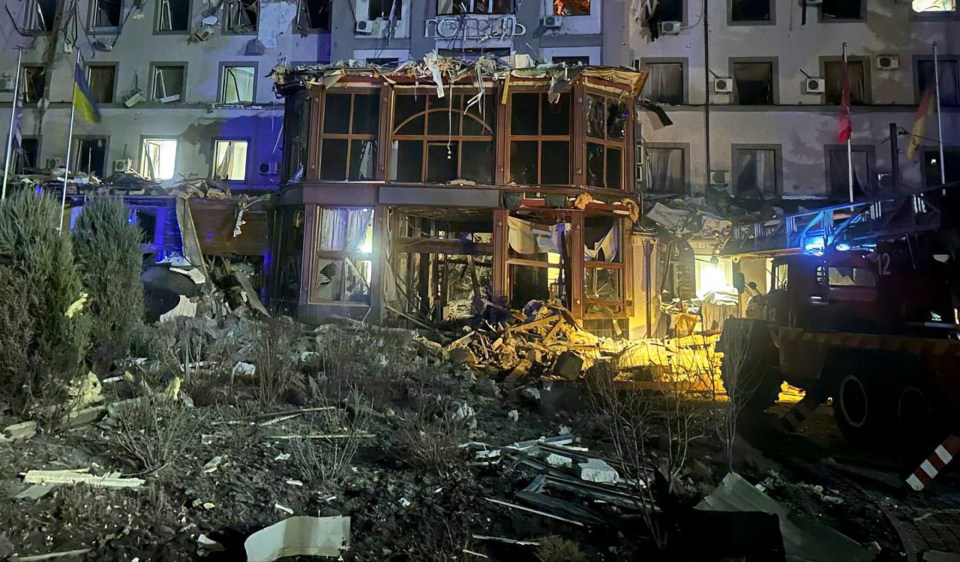 A rocket-hit hotel in Kryvyi Rih, Ukraine, with rescue workers present.