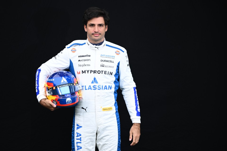 Carlos Sainz in Williams racing suit holding his helmet.