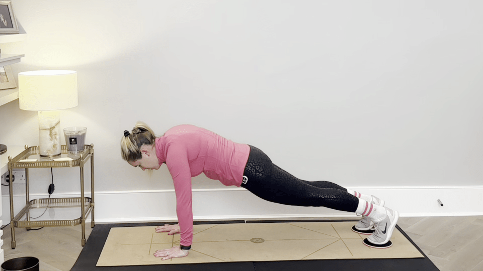 Woman performing a core-strengthening slider exercise.