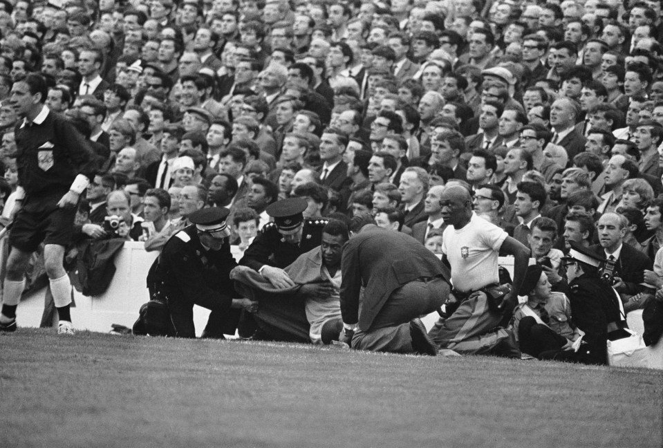 Injured Pelé being attended to by medical personnel on the field.