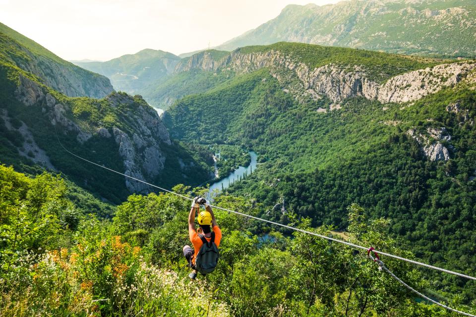 Person ziplining over a canyon.