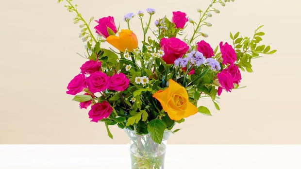 Bouquet of pink and yellow roses in a vase.