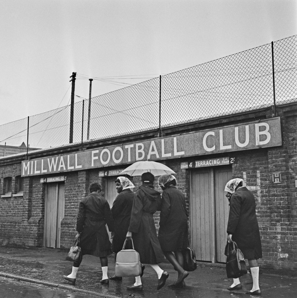 Black and white photo of women walking near the Millwall Football Club in London.