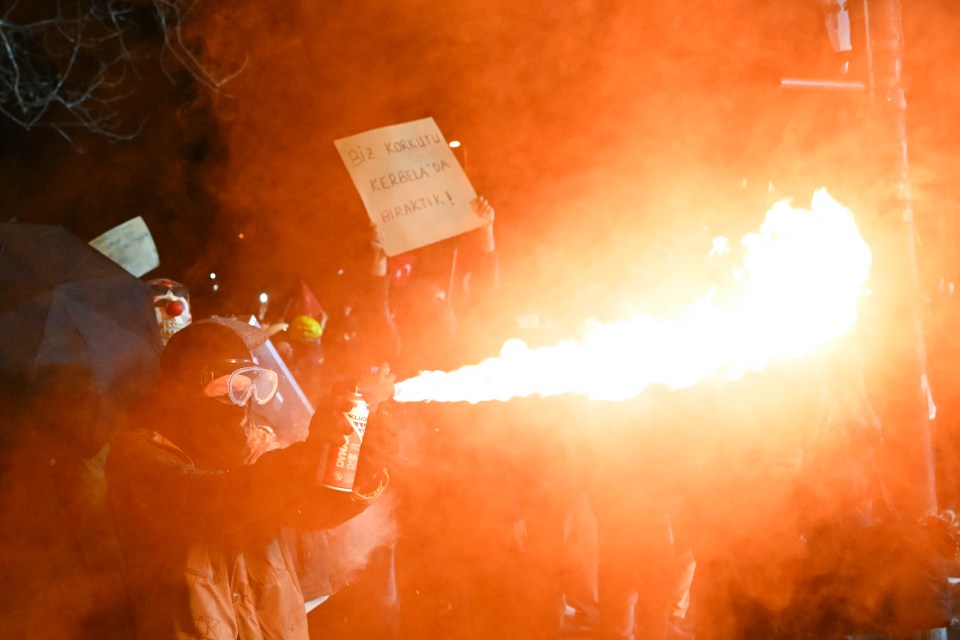 Protestor igniting gas spray during a demonstration.