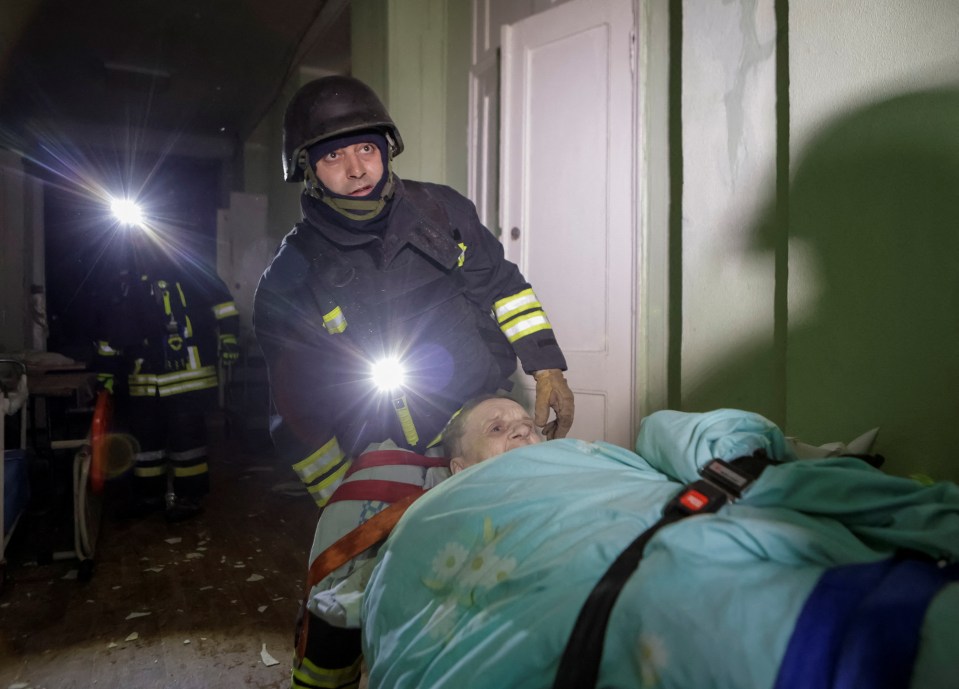 Rescuers evacuating a person from a damaged hospital.