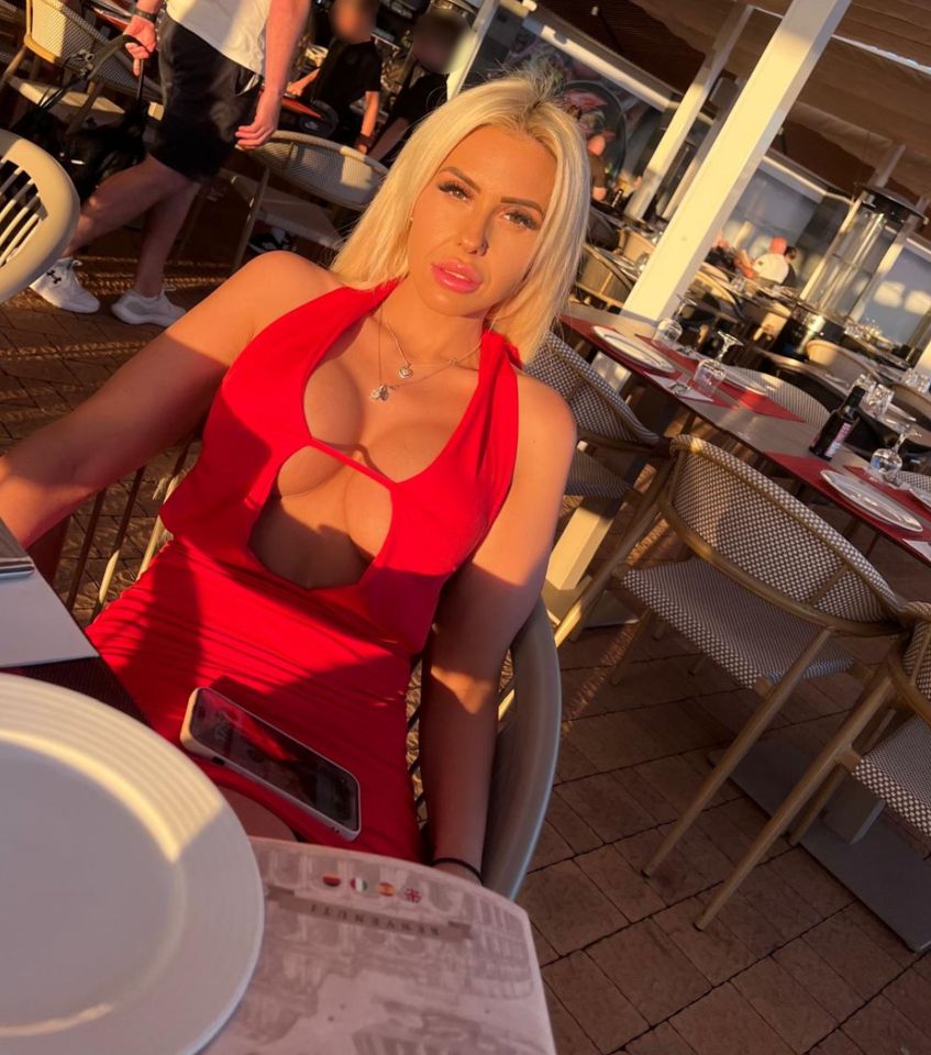 Woman in red dress at outdoor restaurant.