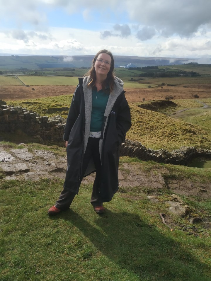 Woman standing by Hadrian's Wall.