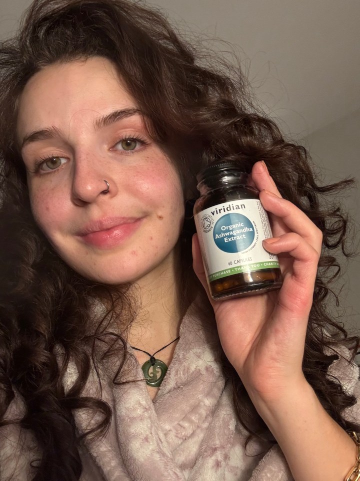 Woman holding bottle of Ashwagandha extract.