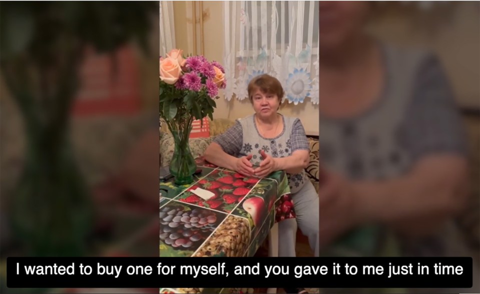 A woman sits at a table, talking about receiving a meat grinder.