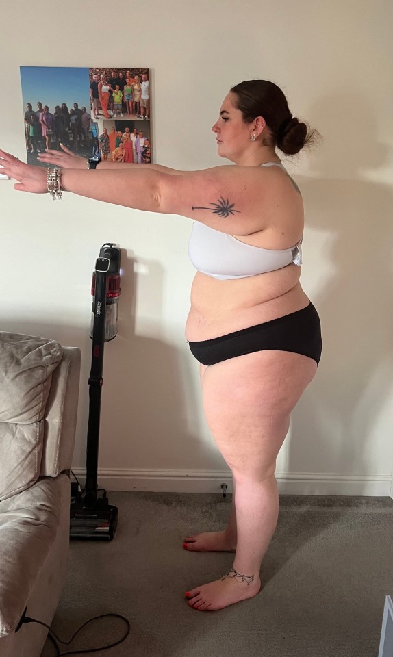 Woman in underwear, arms outstretched, side profile.