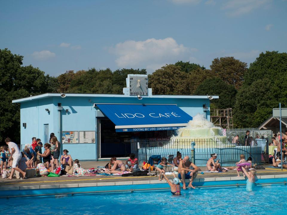 Tooting Bec Lido cafe and pool with sunbathers.